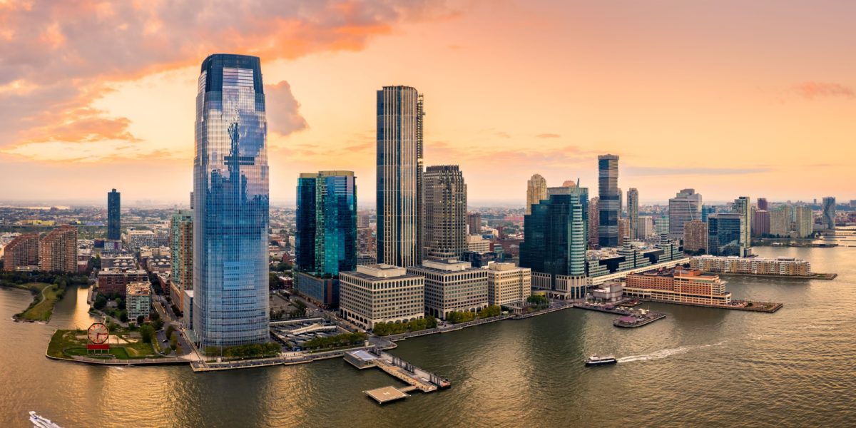 Aerial panorama of Jersey City skyline at sunset.