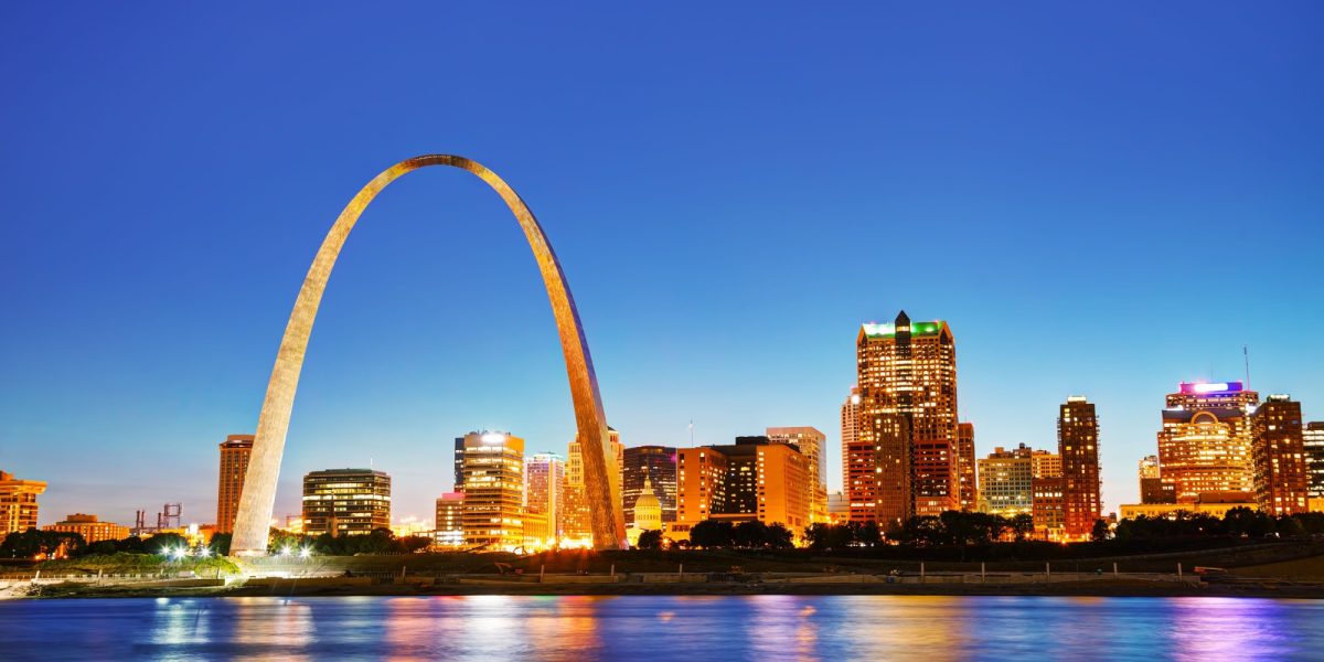 Downtown St Louis, MO with the Old Courthouse and the Gateway Arch at sunset